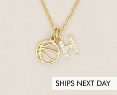 a gold necklace with the letter h on it and a basketball ball hanging from it