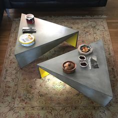 a coffee table with two triangular shaped tables on top of it in a living room