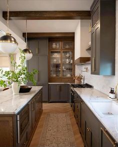 a large kitchen with marble counter tops and wooden cabinets, along with an area rug that matches the hardwood flooring