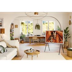 a living room filled with furniture and a flat screen tv on top of a wooden table