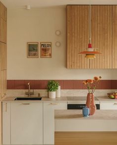 a vase with flowers in it sitting on a kitchen counter