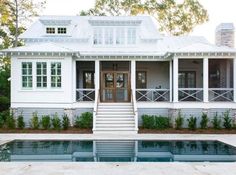 a house with a pool in front of it and stairs leading up to the upper floor