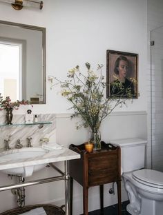 a bathroom with a sink, toilet and mirror on the wall next to a window