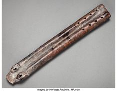 an old wooden instrument with holes in it