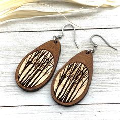 "Beautiful trees reminiscent of a long walk in the woods. Tree in tear drop shape, deep engraved earrings in maple wood. Cut and deep engraved from Maple wood, lightweight and natural Earwires of Stainless Steel Fish Hook style Stainless Steel Earwires Tear drop shape 1 1/2\" long by 3/4\" wide Stainless steel / non-tarnish / no plating See Care and Wear Instructions on home page Matching Pendants also available ⓒ All Designs and Images are copyrighted by Be Inspired UP. All Rights Reserved." Laser Engraved Earrings, Matching Pendants, Wood Hoop Earrings, Engraved Earrings, Laser Engraved Ideas, Wood Burning Crafts, Beautiful Trees, Glass Locket, Long Walk