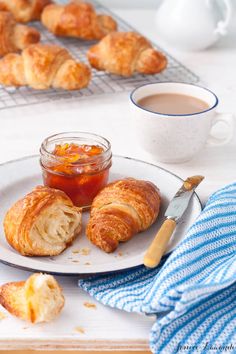 croissants and jam on a plate with a blue towel next to them