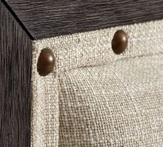 a close up view of some buttons on a piece of fabric with wood in the background