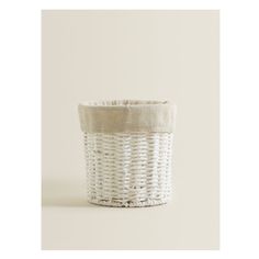 a white wicker basket with a linen lining