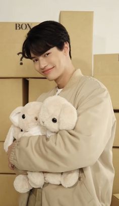 a man holding two white teddy bears in his hands