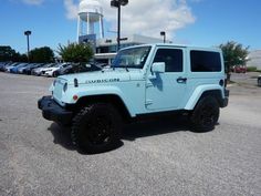 a light blue jeep parked in a parking lot