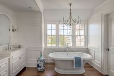 a bathroom with a claw foot tub and chandelier