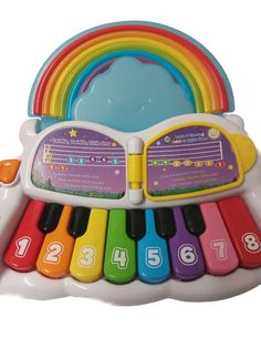 an electronic toy piano with rainbows and numbers on the keys, sitting in front of a white background