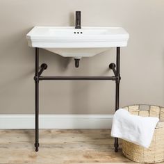 a white sink sitting on top of a bathroom counter next to a towel dispenser