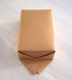 an origami box sitting on top of a white tablecloth covered flooring