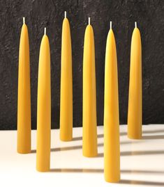 several yellow candles are lined up in a row