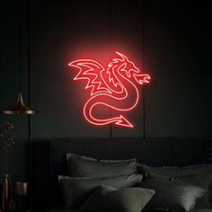 a red dragon neon sign mounted to the side of a wall next to a bed