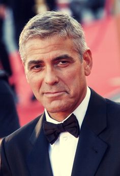 Elegant Caesar Cut - If you’re looking for an especially suave style, consider copying Clooney’s hair here. His full, slicked back style is an ideal choice for a refined hairstyle that will showcase grey hair. The Master Barber from Ted’s Grooming Room in London says that “silver locks convey a sense of sophistication, experience, and power.” This hairstyle brings out those three elements for an outstanding look. Ask your barber for 2 to 3 inches on top of the head. The hair should be a little l Old Man Hairstyles, Dapper Haircut, Top Haircuts For Men, Caesar Haircut, Face Tone