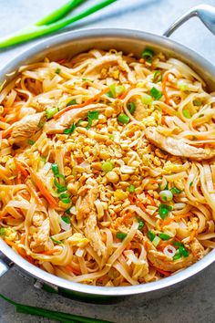 a pan filled with noodles and vegetables on top of a table