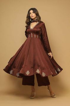 a woman in a maroon dress standing on a brown background