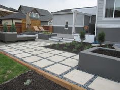 an outdoor patio with seating and landscaping in the background