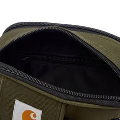 the inside of a green and black bag with an orange logo on it's side