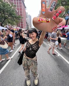 a woman is holding up her hand in the street