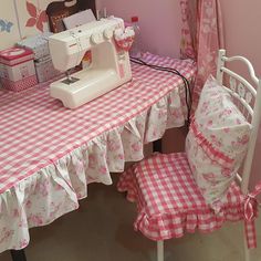 a sewing machine sitting on top of a table next to a baby crib and chair