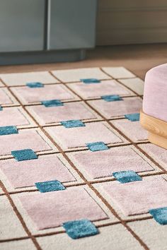 a pink rug with blue squares on it