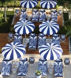 an aerial view of blue and white patio furniture with umbrellas on the top floor