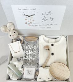 an open box containing items from the baby's first christmas gift set, including a teddy bear and sweater