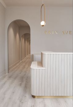 an empty room with white walls and wooden floors, along with a gold framed sign that reads skin ave