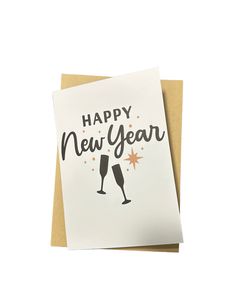 a card with the words happy new year and two champagne glasses on it, against a white background