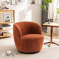 an orange chair sitting on top of a white floor next to a wooden table and bookshelf