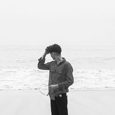 a man standing on top of a beach next to the ocean