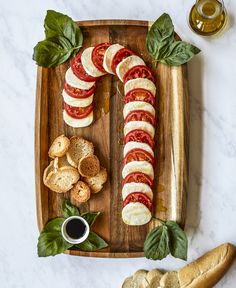 a wooden cutting board topped with slices of bread and sliced tomatoes on top of it