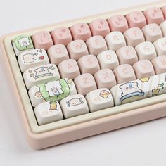 a pink and white computer keyboard with hello kitty stickers on it's keys