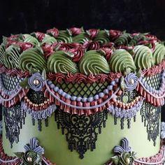 an elaborately decorated cake with green frosting and red icing on it's sides