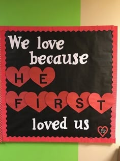 a bulletin board that says we love because he first loved us with hearts on it