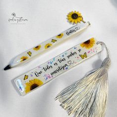 two pens with sunflowers on them next to a tassel