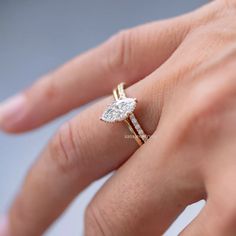 a woman's hand with a diamond ring on top of her finger and an engagement band