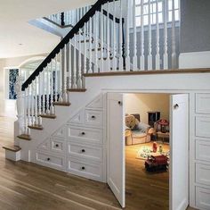 an open door leading to a living room with stairs and storage units in it,