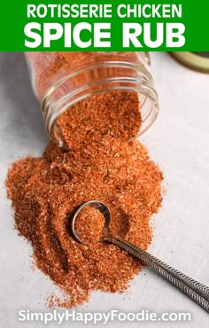 an open jar filled with spices next to a metal spoon on top of a table