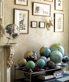 a living room filled with lots of different types of globes on top of a table