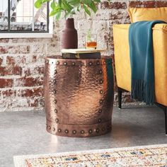 a living room with brick walls and a gold chair next to a potted plant