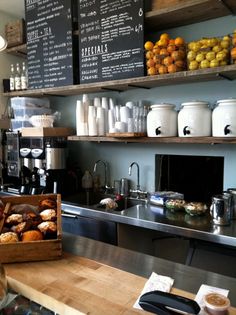 a coffee shop filled with lots of different types of food and drinks on wooden shelves