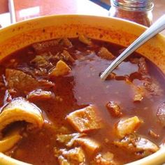 a yellow bowl filled with meat and vegetable soup