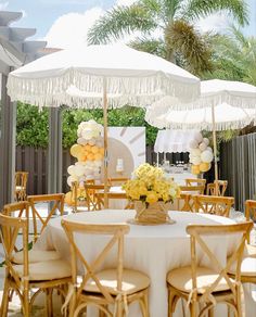 an outdoor dining area with tables, chairs and umbrellas set up for a party