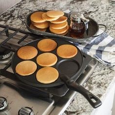 pancakes are being cooked in a cast iron skillet on top of the gas stove