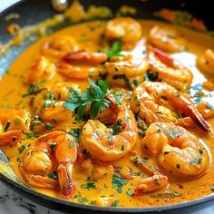 a pan filled with shrimp and sauce on top of a table