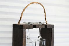 a wine glass holder with two empty glasses in it and a rope hanging from the top